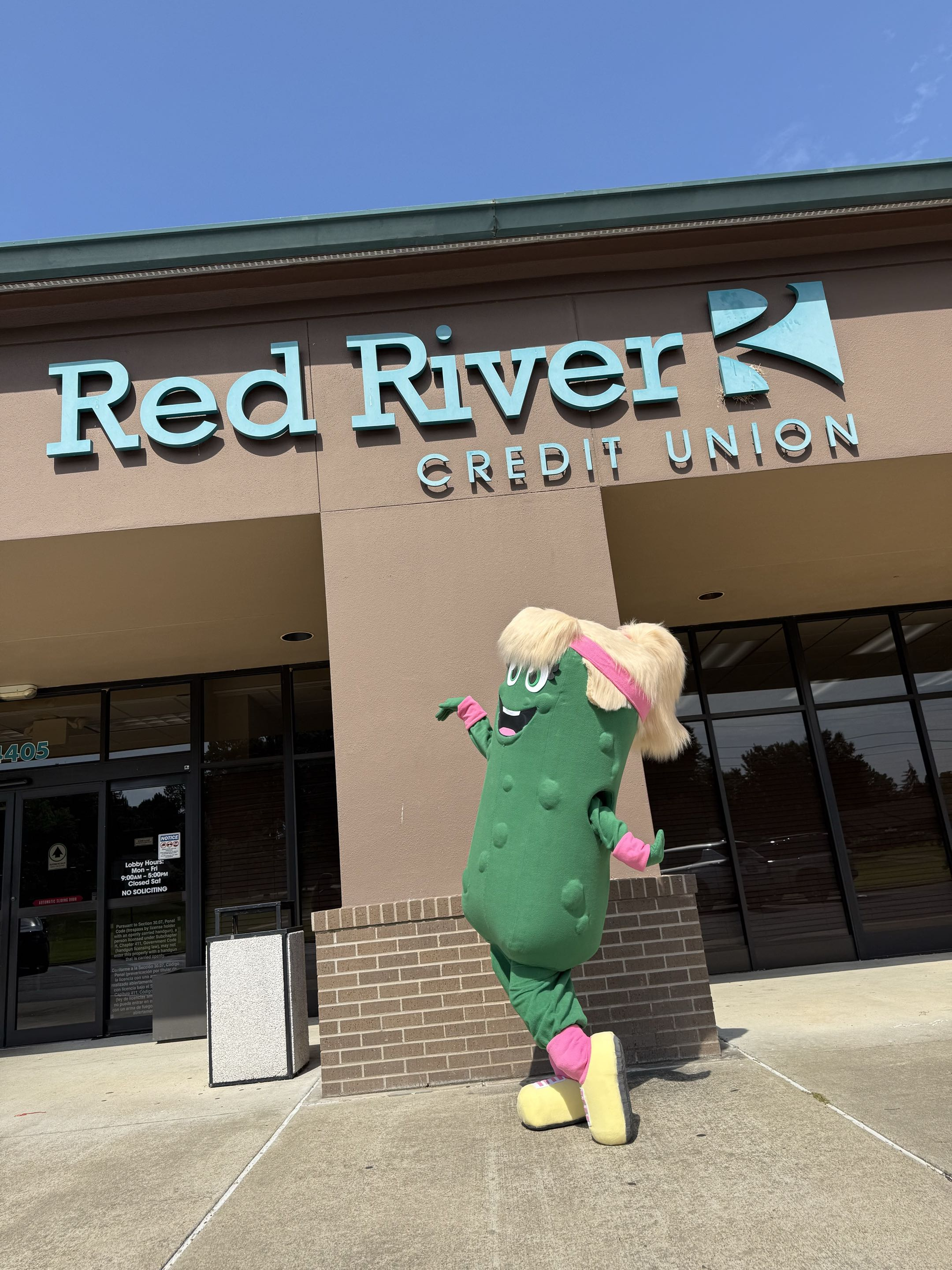 Paddy the Pickle in front of Red River Credit Union